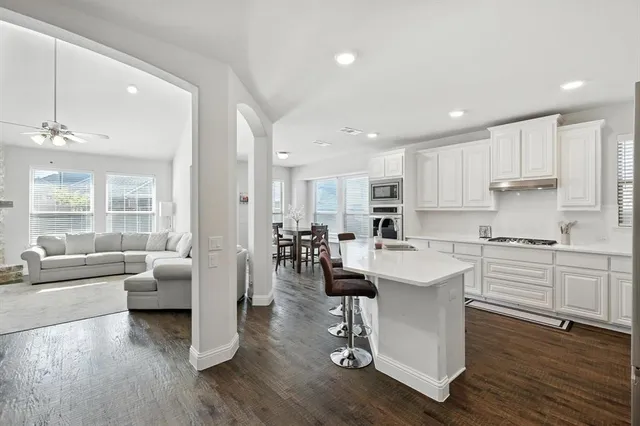 a kitchen with counter top space sink stove and wooden floor
