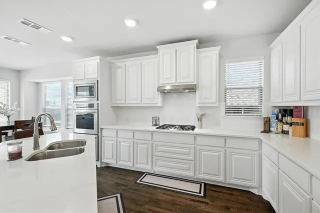 a kitchen with cabinets appliances a sink and a counter top space