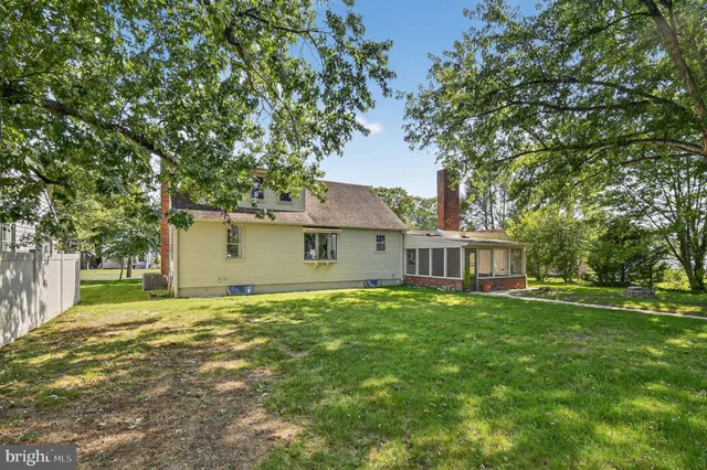 a front view of a house with a garden and trees