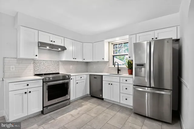 a kitchen with stainless steel appliances granite countertop a refrigerator sink and stove