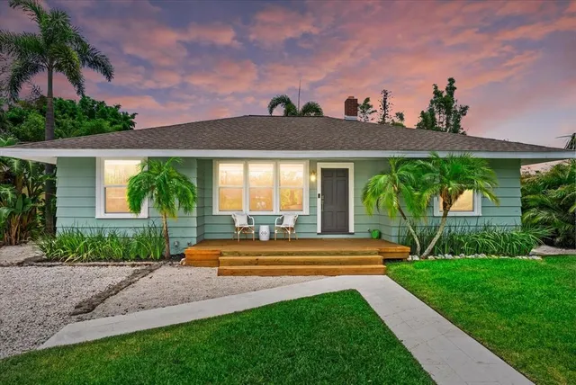 a front view of a house with a yard and potted plants