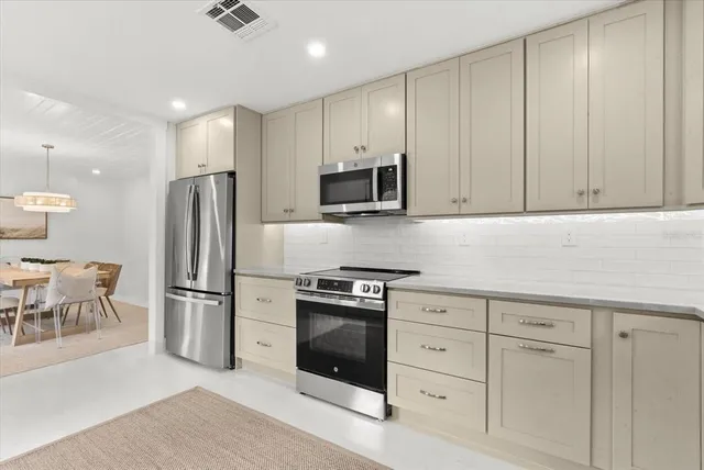 a kitchen with a refrigerator stove and white cabinets
