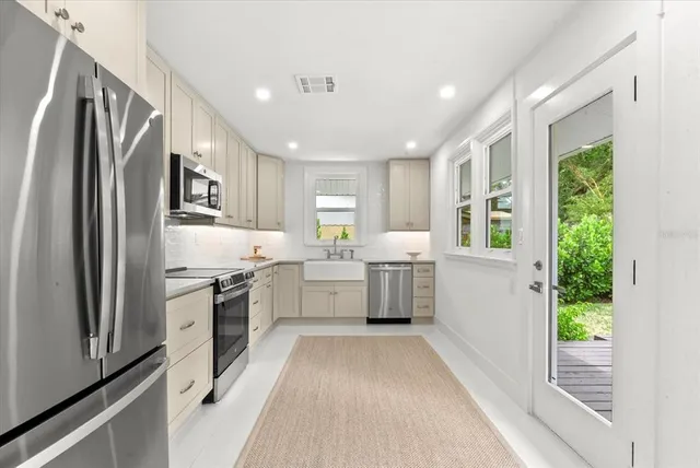 a large kitchen with a large window and stainless steel appliances