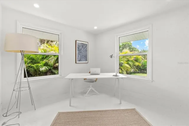 a work space with wooden floor and windows