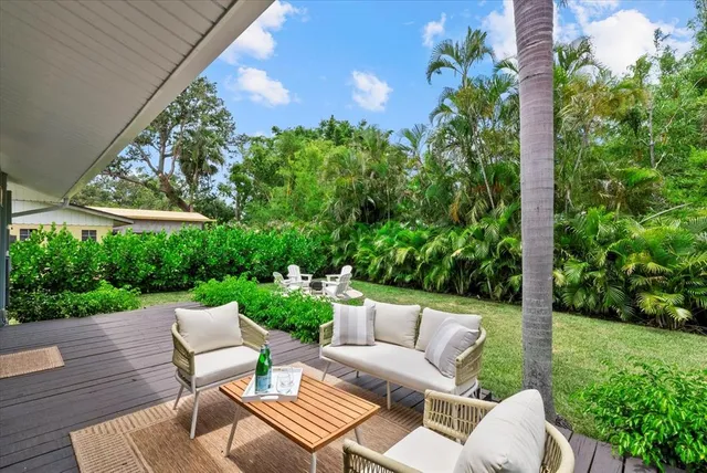 a view of a patio with couches table and chairs and potted plants