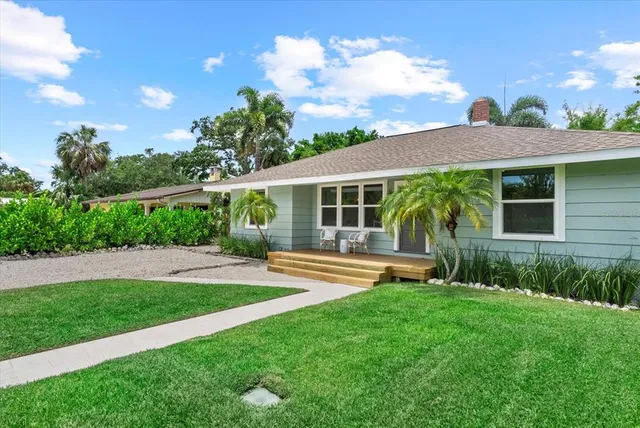 a front view of a house with a yard and green space