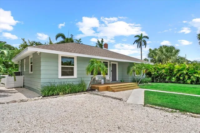 a front view of a house with a yard and potted plants