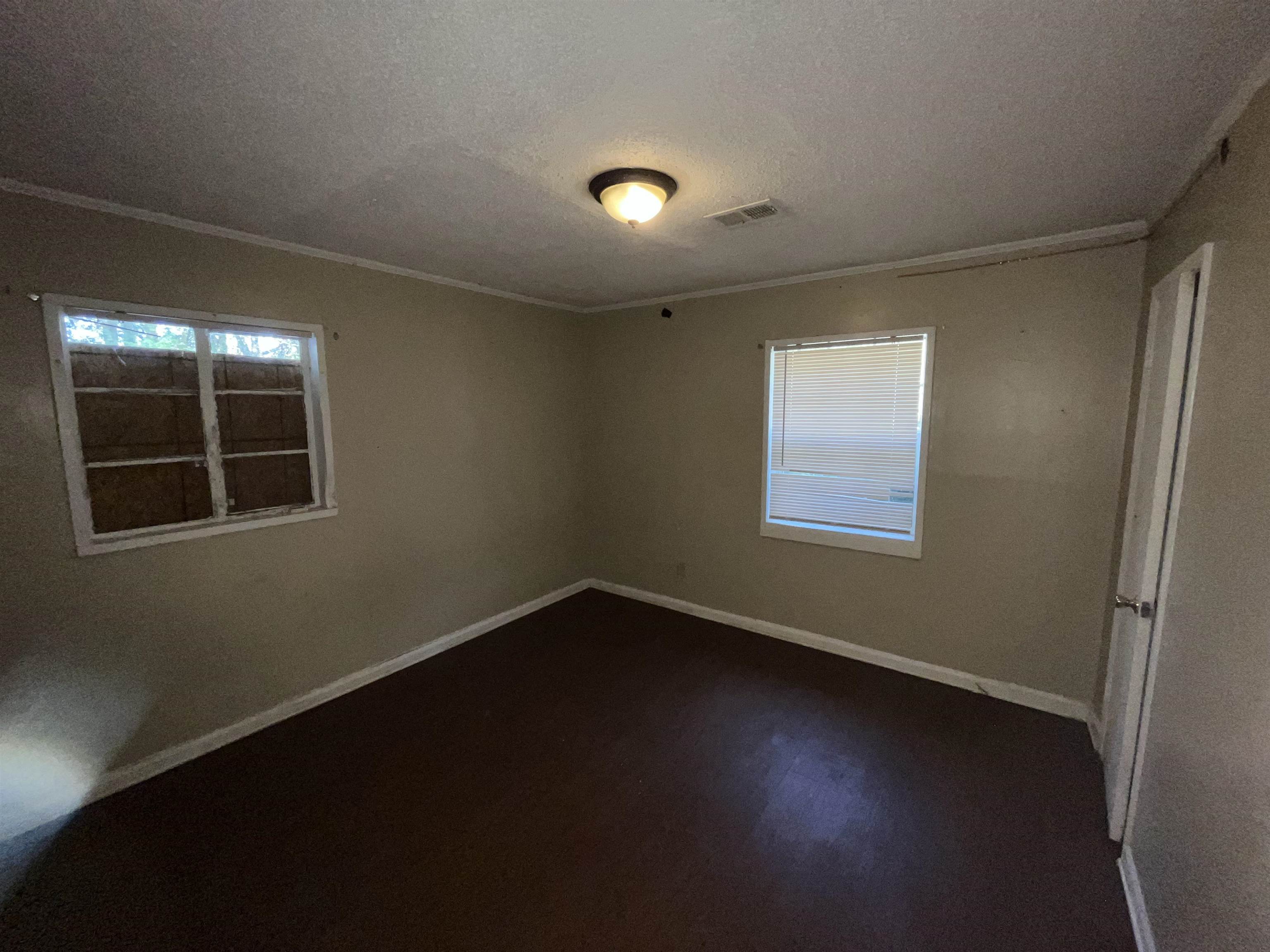 691 Delta Road Memphis, TN 38109 - Photo 18 of 25 a view of an empty room with wooden floor and a window