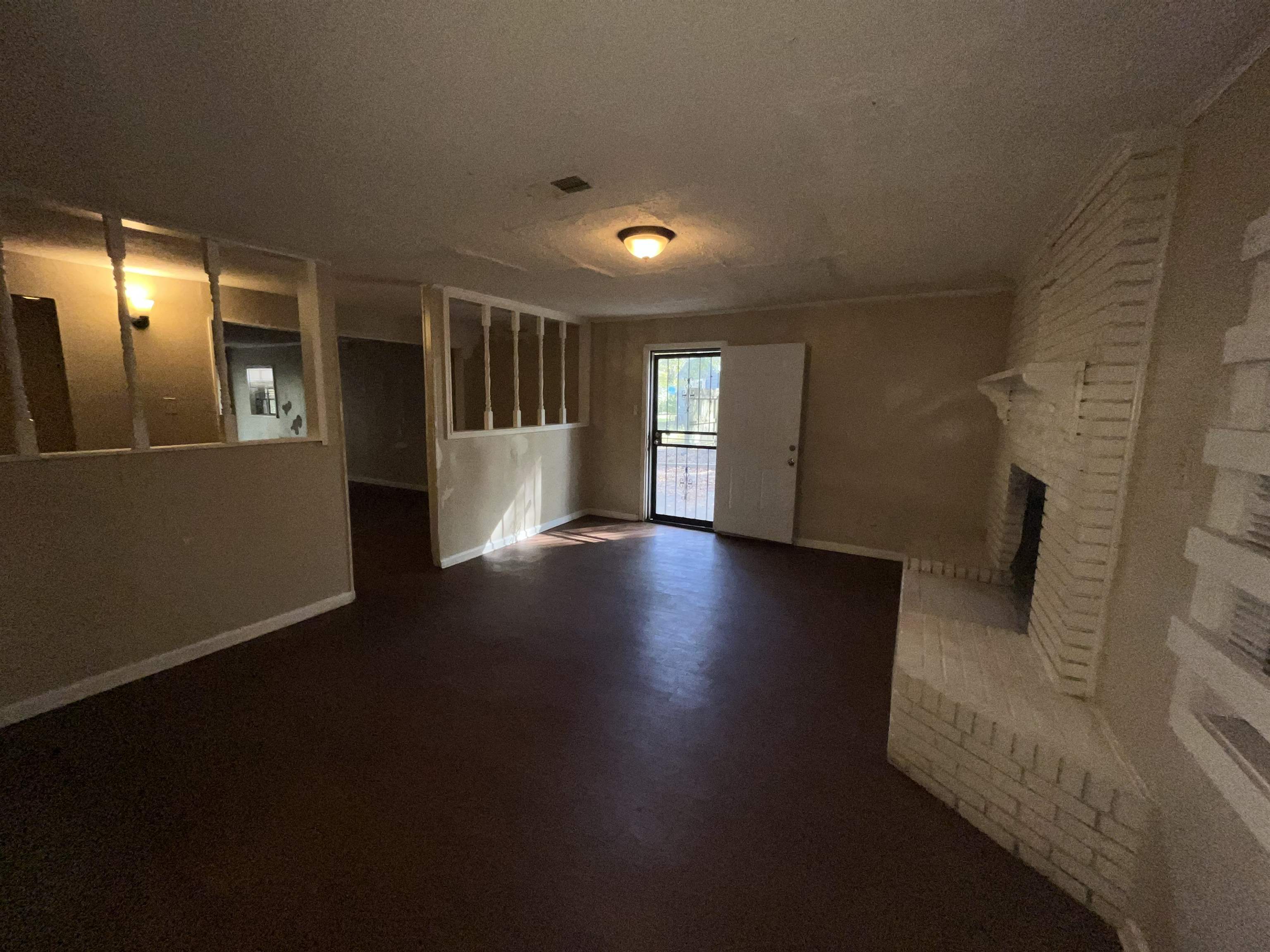 691 Delta Road Memphis, TN 38109 - Photo 10 of 25 a view of an empty room with wooden floor and a window