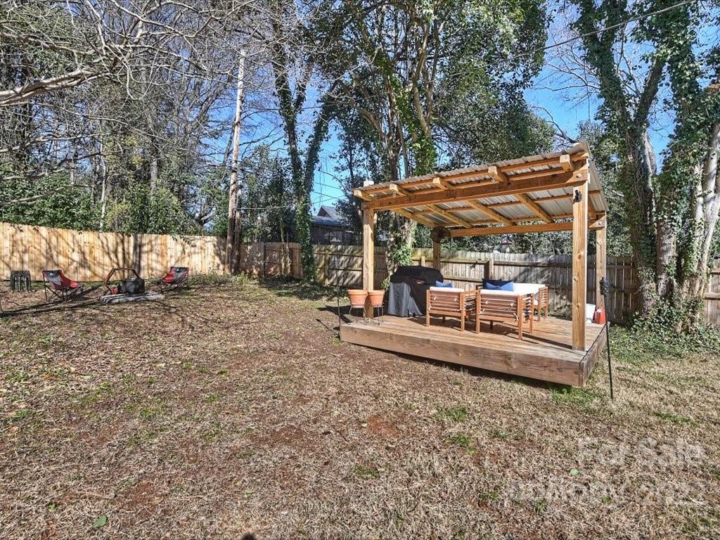 2734 Cowles Road Charlotte, NC 28208 - Photo 23 of 26 a view of a backyard with table and chairs under an umbrella