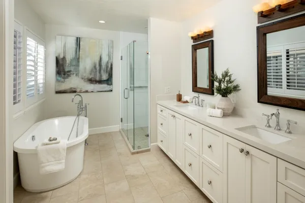 a bathroom with a double vanity sink a mirror and a bathtub