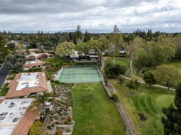 an aerial view of a swimming pool with a yard and outdoor seating