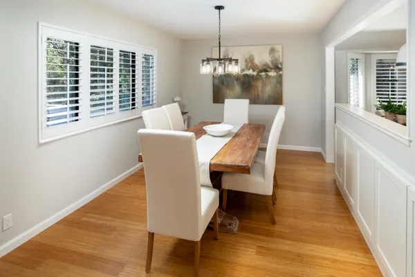 a dining room with furniture a chandelier and wooden floor