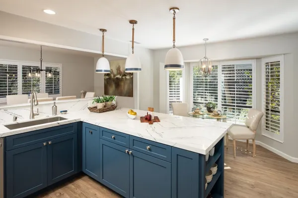 a kitchen with a sink a window and chairs