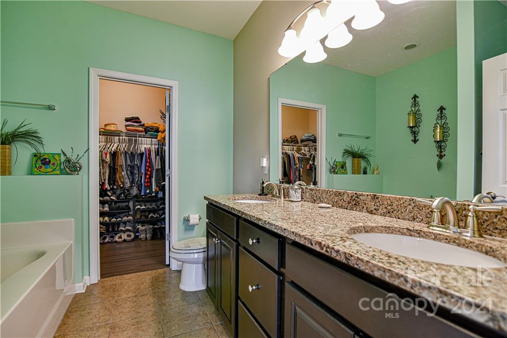 74 North River Road Fletcher, NC 28732 - Photo 16 of 29 a bathroom with a granite countertop sink a toilet a mirror a vanity and shower