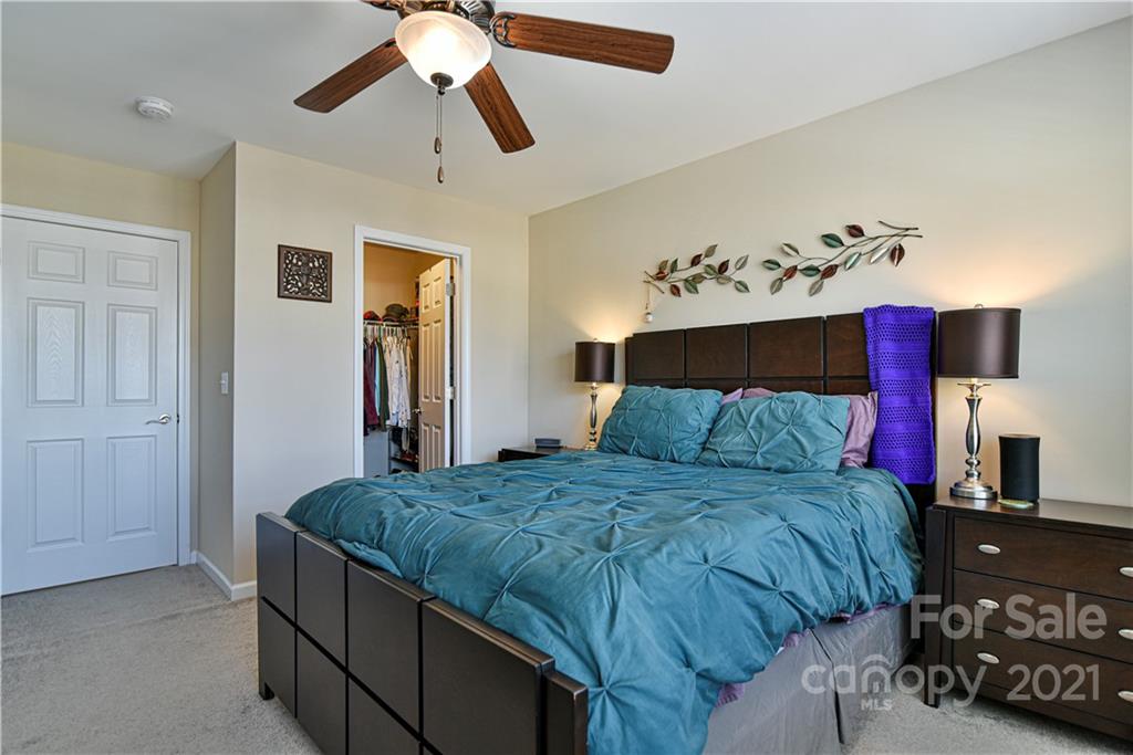 74 North River Road Fletcher, NC 28732 - Photo 19 of 29 a bedroom with a bed and a chandelier