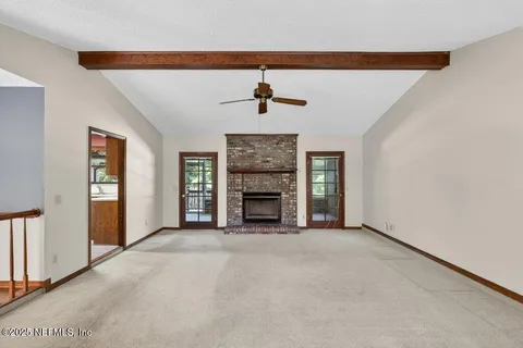a view of an empty room with a fireplace and a window