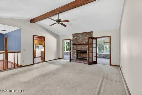a view of empty room with fireplace and fan