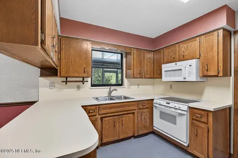 a kitchen with a sink stove and cabinets