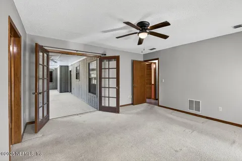 a view of a livingroom with a ceiling fan and entryway