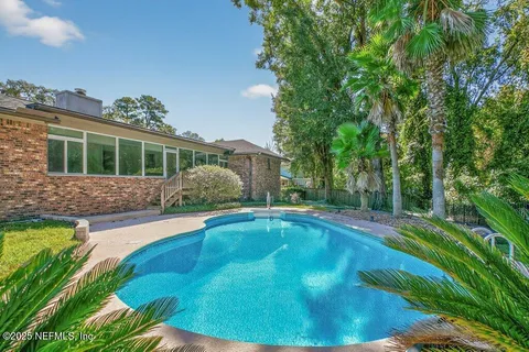 a swimming pool with outdoor seating and yard