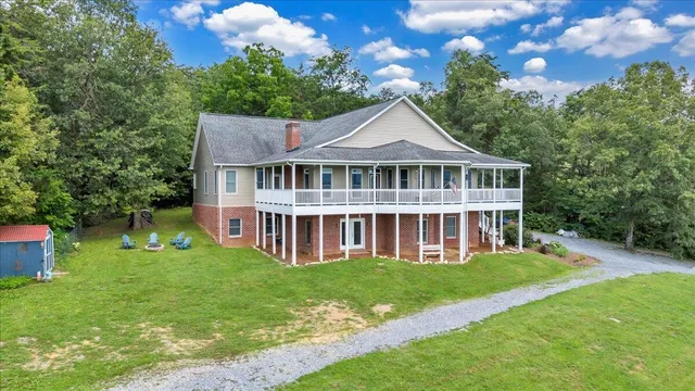 a view of a house with a big yard and large trees