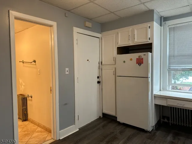 a white refrigerator freezer and a wooden floor