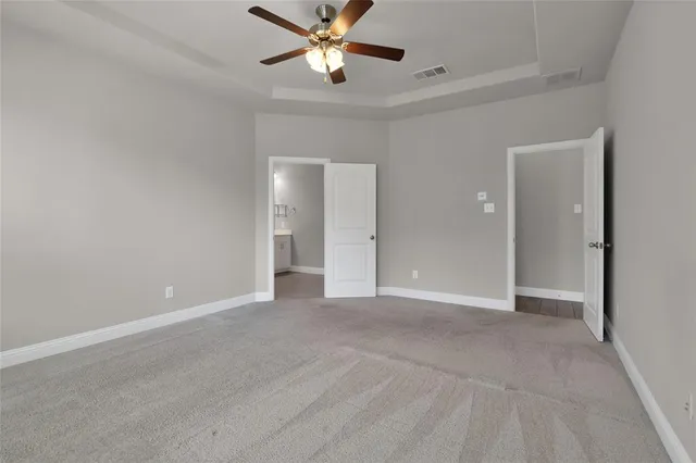 an empty room with closet and a chandelier fan