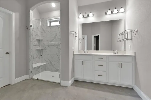 a bathroom with a double vanity sink mirror and bathtub