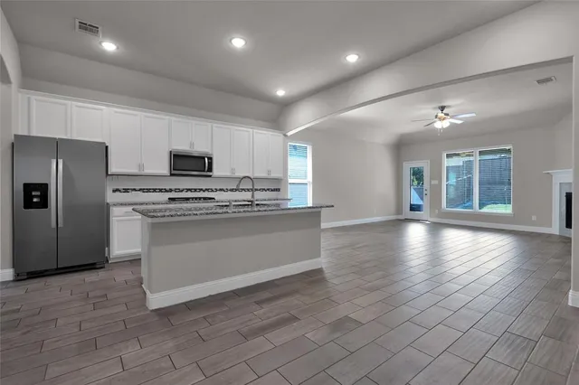 a kitchen with stainless steel appliances a refrigerator sink and microwave