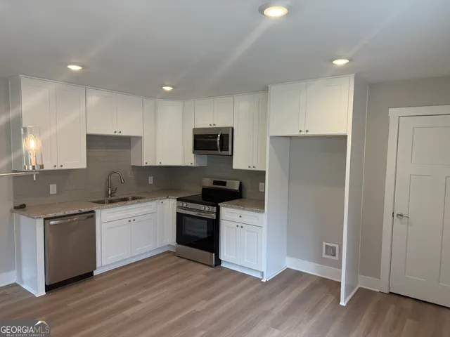 a kitchen with granite countertop a sink and steel appliances