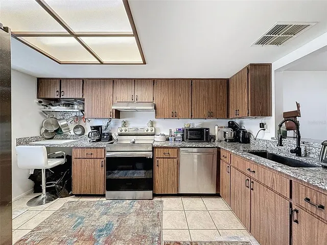 a kitchen with stainless steel appliances granite countertop a stove sink and cabinets