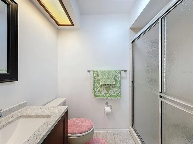 a bathroom with a granite countertop toilet and a sink