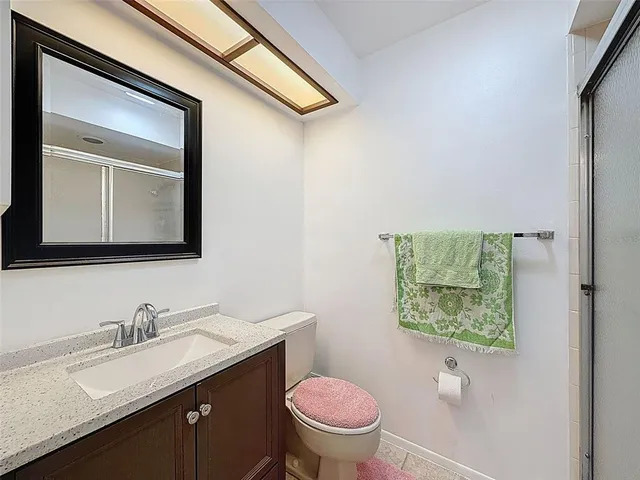 a bathroom with a granite countertop toilet sink and mirror