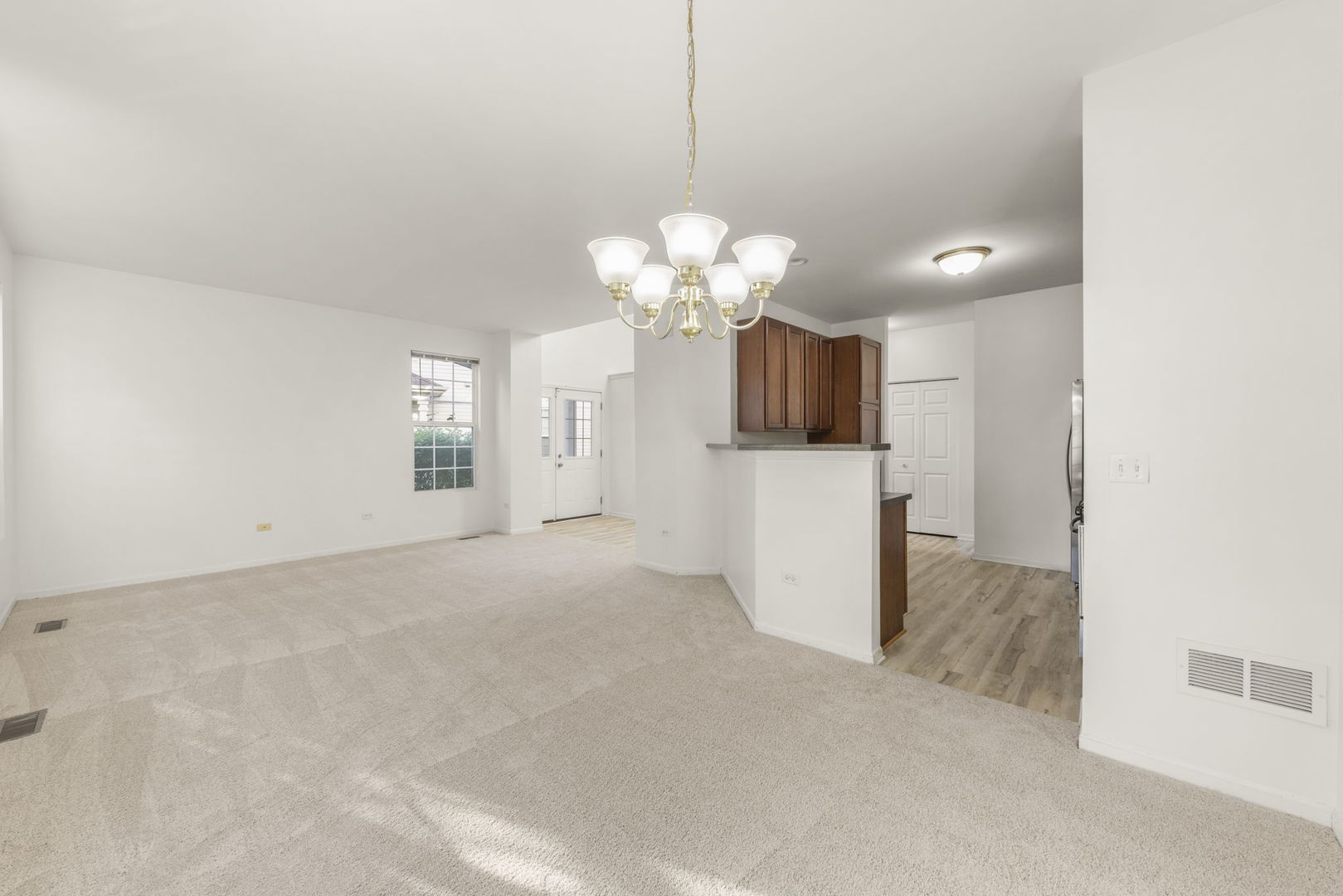 274 South Oak Creek Lane Romeoville, IL 60446 - Photo 6 of 19 a view of a kitchen with a sink a chandelier a refrigerator and a chandelier