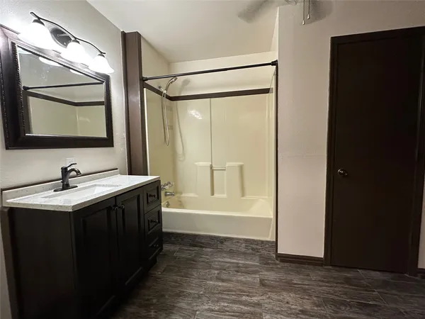 a view of a hallway with wooden floor and a living room