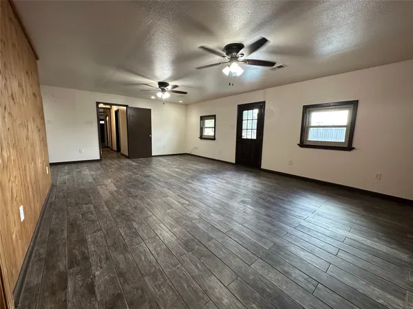 a view of a room with wooden floor and ceiling fan
