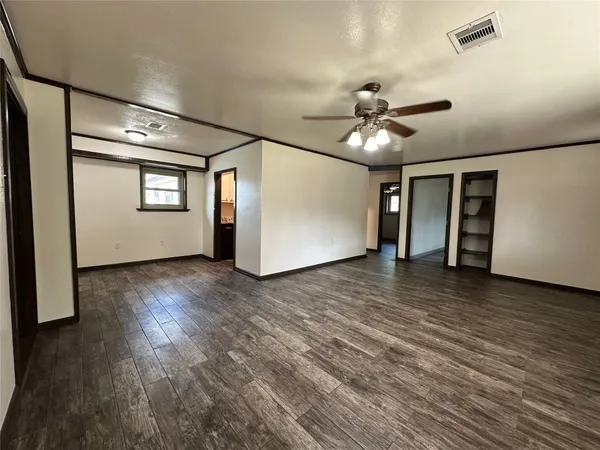 a view of a livingroom with a ceiling fan window and wooden floor
