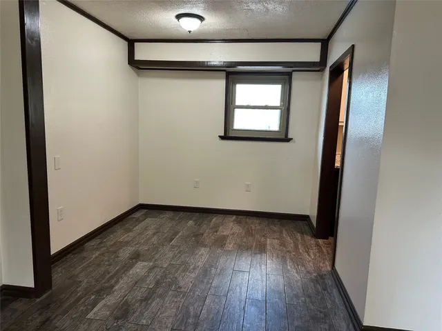 a view of a hallway with wooden floor and a window