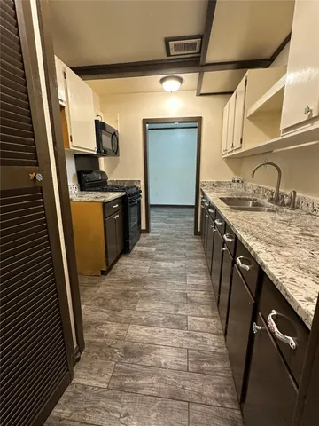 a kitchen with a sink stove and cabinets