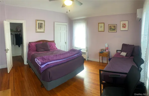 a spacious bedroom with a bed and wooden floor