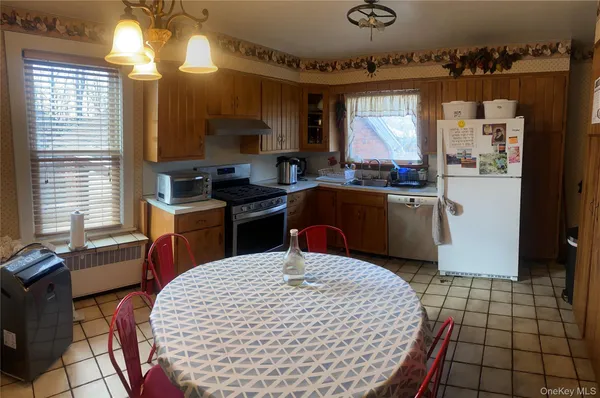 a kitchen with stainless steel appliances kitchen island granite countertop a sink a stove counter space and cabinets