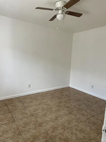 an empty room with a fan and a fan