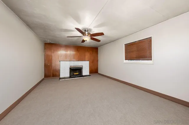 an empty room with windows and fireplace