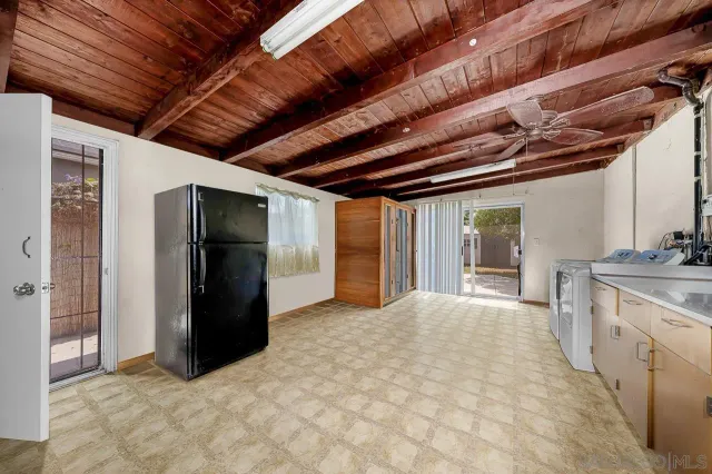 a view of hallway with refrigerator and cabinet