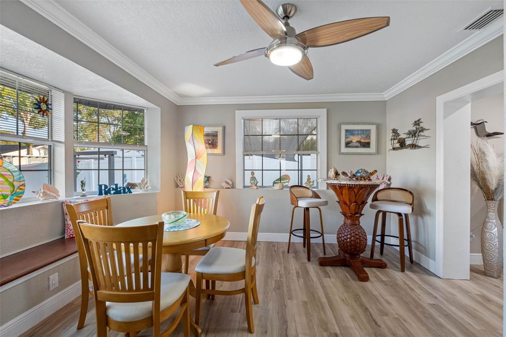8139 129th Lane Seminole, FL 33776 - Photo 13 of 48 a view of a dining room with furniture a chandelier and wooden floor
