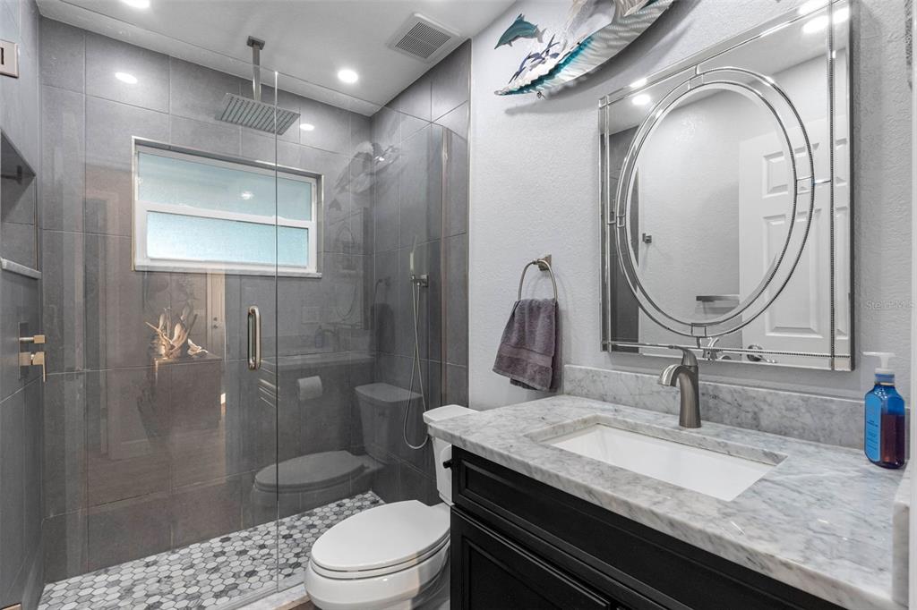 8139 129th Lane Seminole, FL 33776 - Photo 20 of 48 a bathroom with a granite countertop sink a toilet and shower