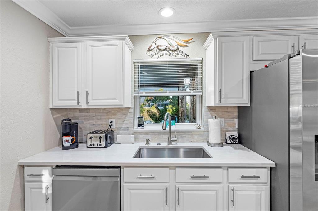 8139 129th Lane Seminole, FL 33776 - Photo 8 of 48 a kitchen with white cabinets and a sink