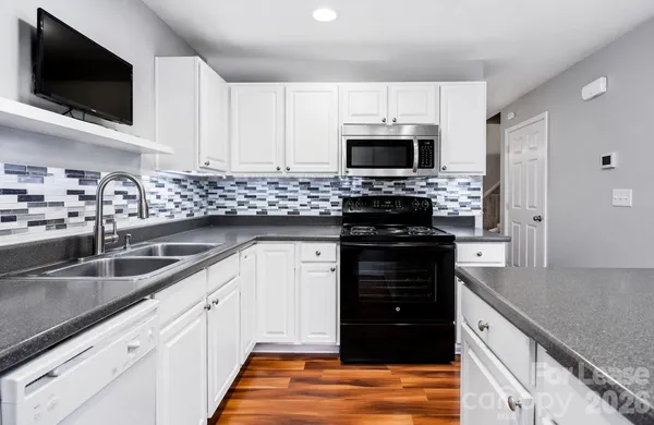 a kitchen with stainless steel appliances granite countertop a stove a sink and a microwave