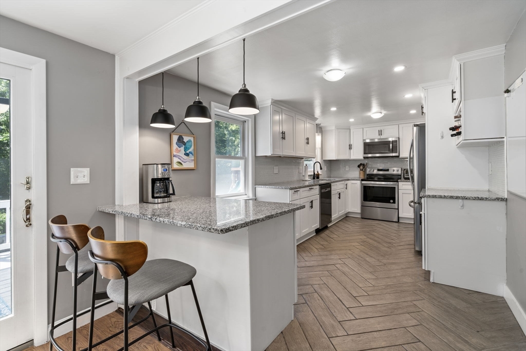 26 Miller Road Easton, MA 02356 - Photo 7 of 29 a kitchen with stainless steel appliances kitchen island granite countertop a table chairs and a refrigerator
